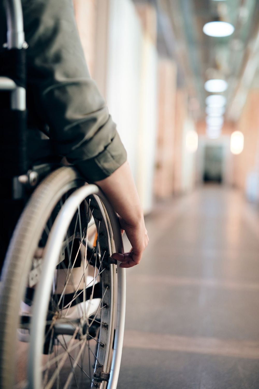 Persona en silla de ruedas avanzando por un pasillo luminoso